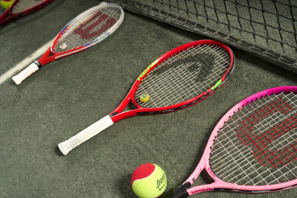 Various Wilson racquets on a racquet sport court.