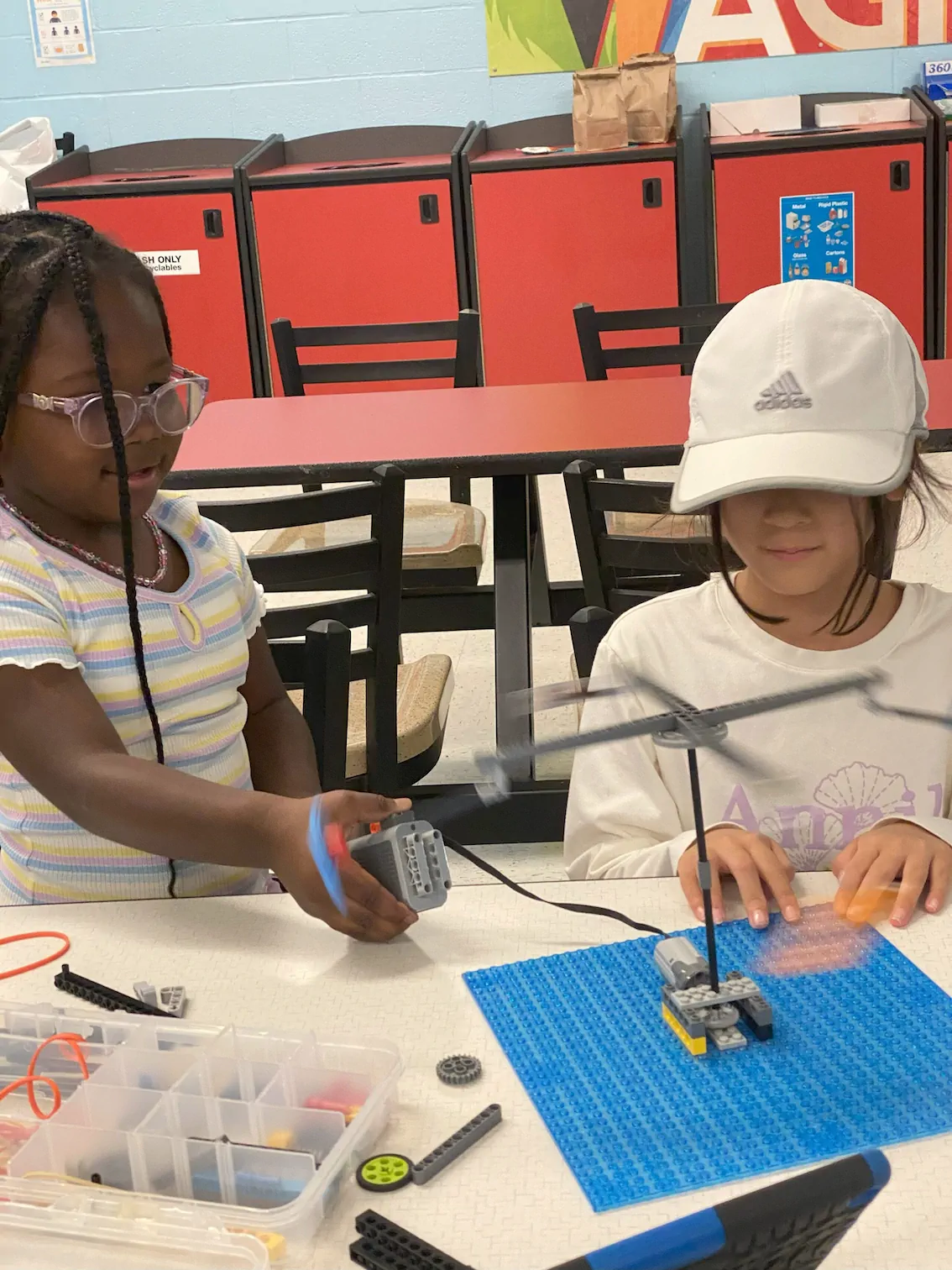 Two young girls learning about physics with Legos.
