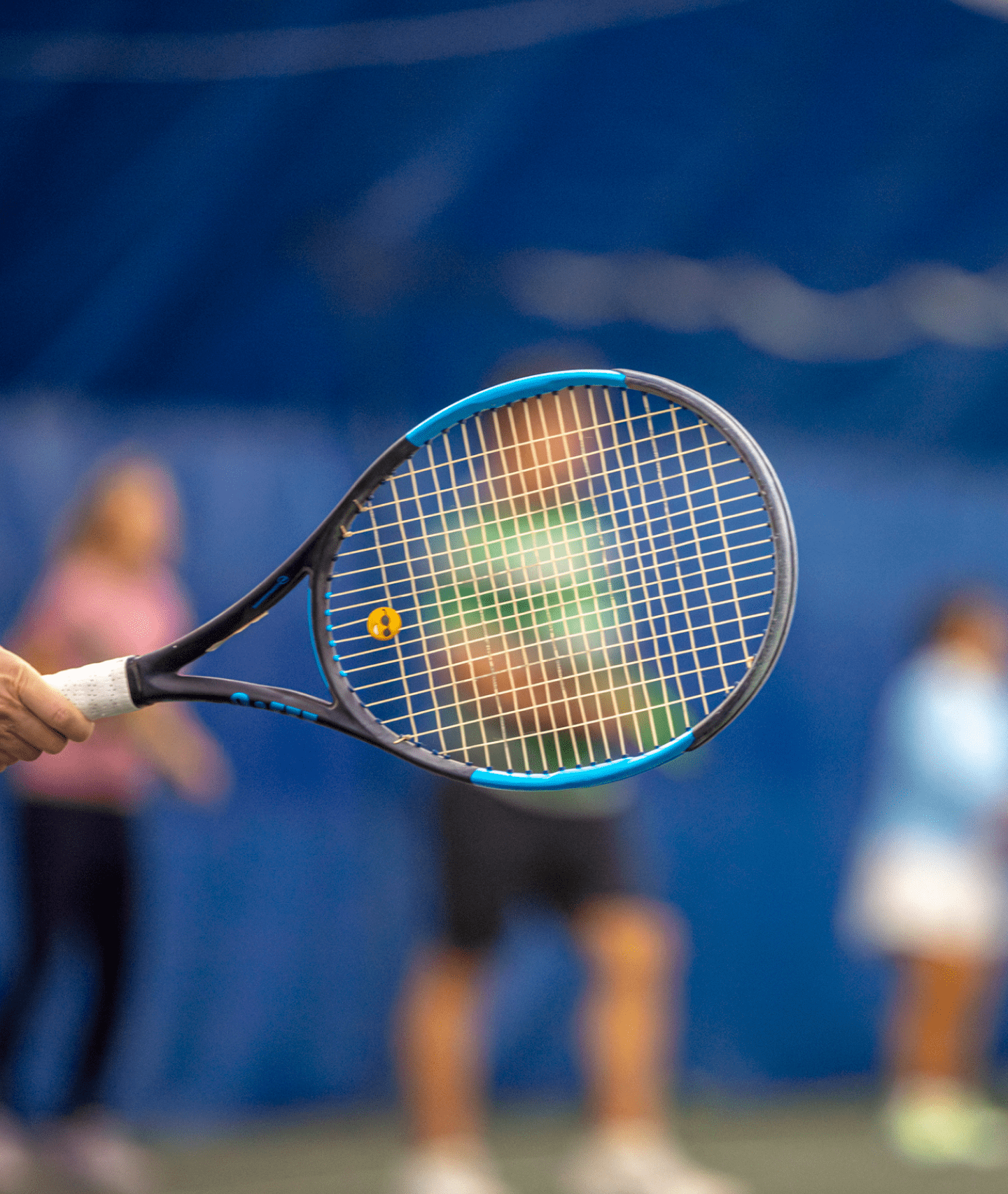 RUCKUS-ADVANTAGETENNIS1_Photo-Adultclasses(2.5-3 12 A coach and player bumping fists over the net after a beginner tennis lesson for adults.