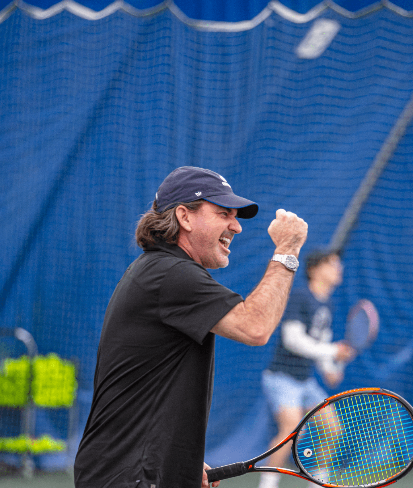 RUCKUS-ADVANTAGETENNIS1_Photo-Adultclasses(2.5-3 14 Tennis coaching and development pro, Tony Huber, pumping his fist excitedly during a tennis lesson.